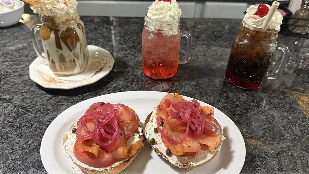 A lox bagel with pickled red onion and capers, a Shirley Temple, a Roy Rogers and a specialty coffee on the counter at Finally Ours